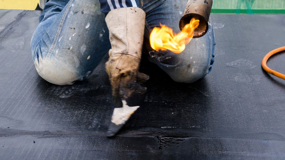 A man lays waterproof roof sheathing and insulation