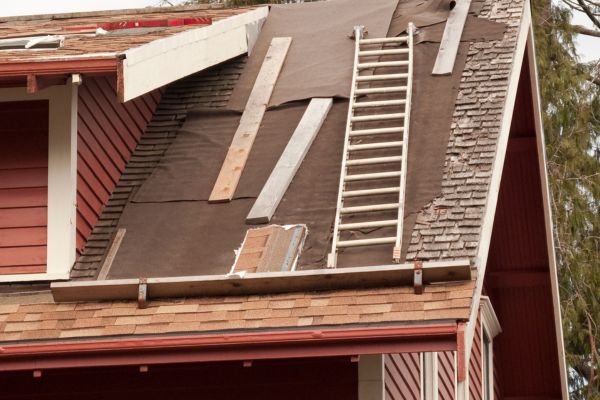 A very steep roof where old cedar shingles are being replaced