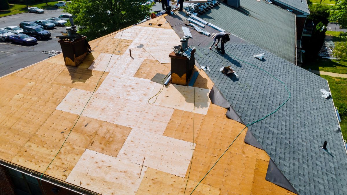 Roofers repair roof underlayment before installing new shingles